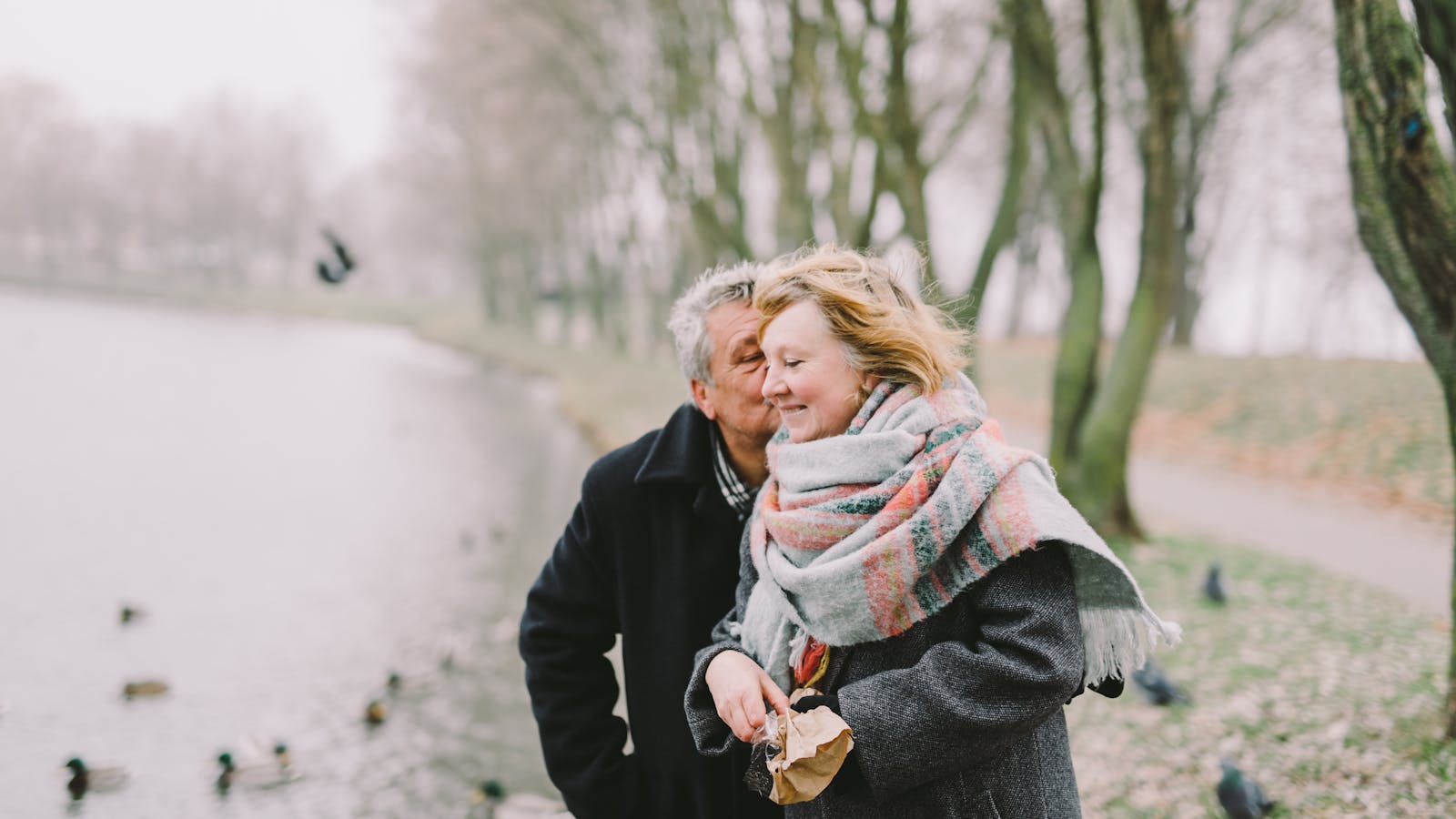Senior couple walking by a lake, representing Florida Medicare beneficiaries reviewing mid-year 2026 coverage
