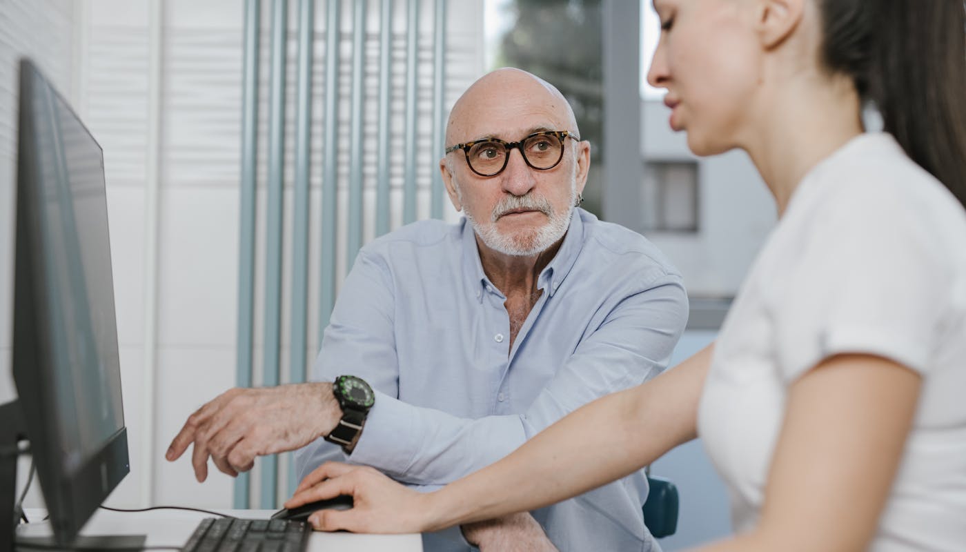 Florida senior man in consultation with his doctor, illustrating concern over Medicare Advantage network changes after forced plan disenrollment in 2026