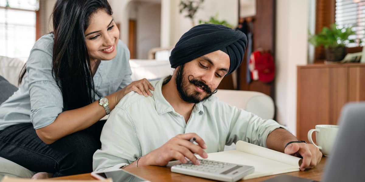 Pareja hispana en Florida revisando su cobertura de salud del ACA en una laptop antes de la inscripción abierta 2027