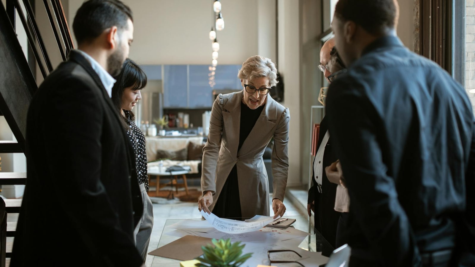 Small business owner and team reviewing documents together around a table
